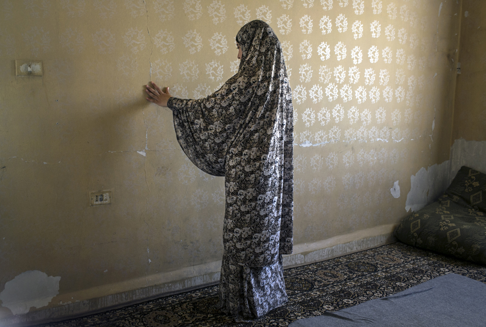 Jordan. Elderly Syrian refugee gathers bread in trash cans to feed her extended family of 15 (selling it to farmers) for two Jordanian dinars a day.
